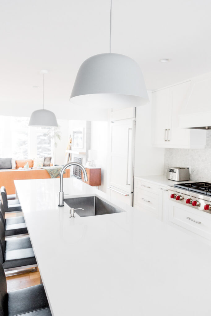 stainless steel kitchen sink in white countertop