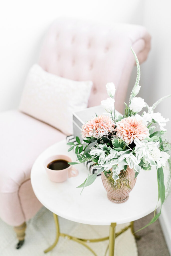 fresh flower arrangement on table next to pink chair