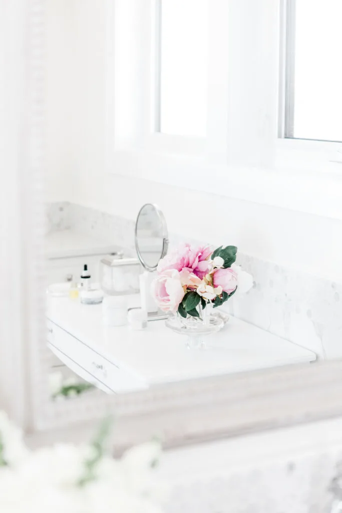 pink flowers in vase in white bathroom