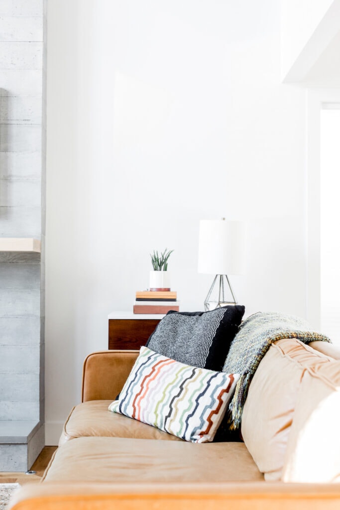 upholstered couch with throw pillows against white wall