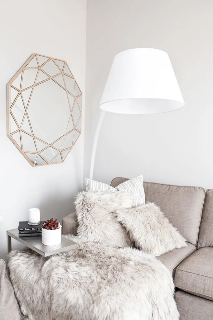grey couch with throw pillows and fuzzy grey blanket