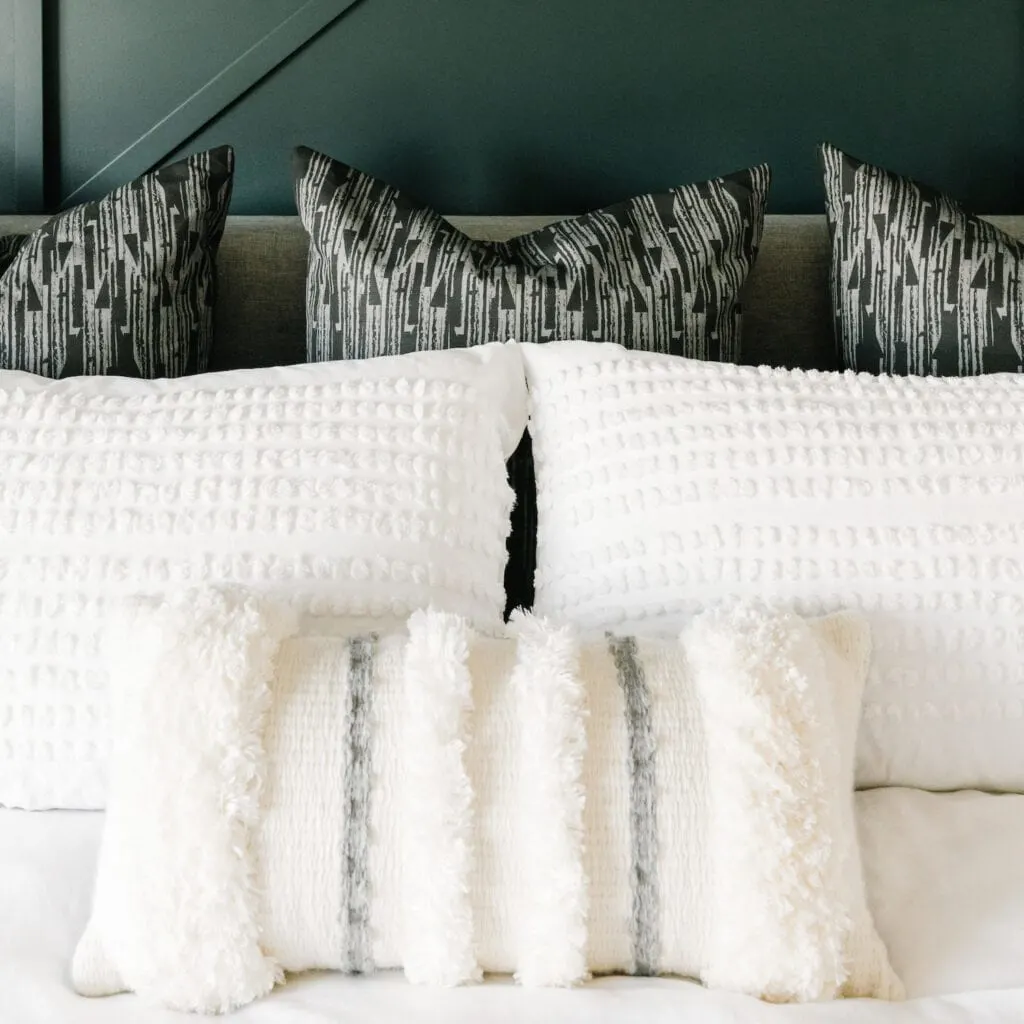 white throw pillows on a bed and white comforter