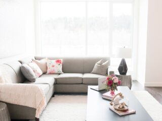 upholstered grey sofa against large windows with natural light