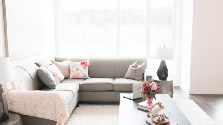 upholstered grey sofa against large windows with natural light