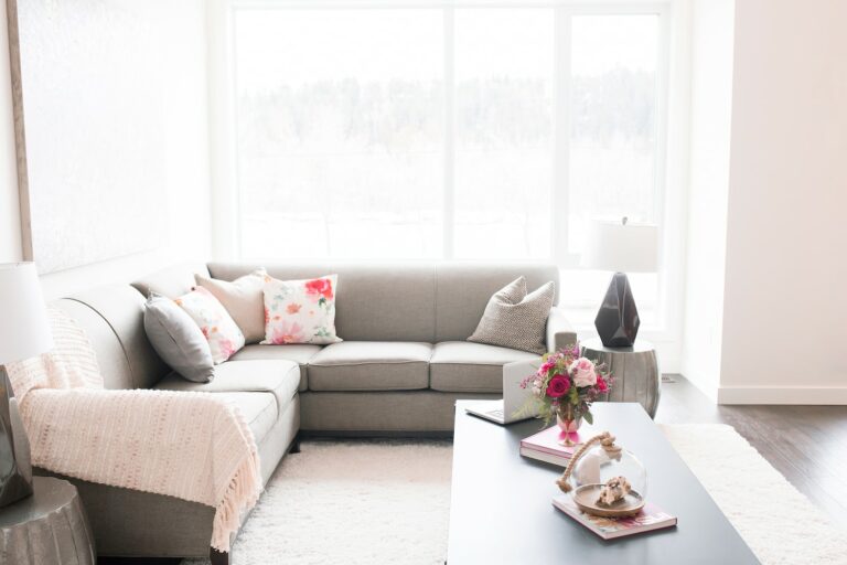 upholstered grey sofa against large windows with natural light