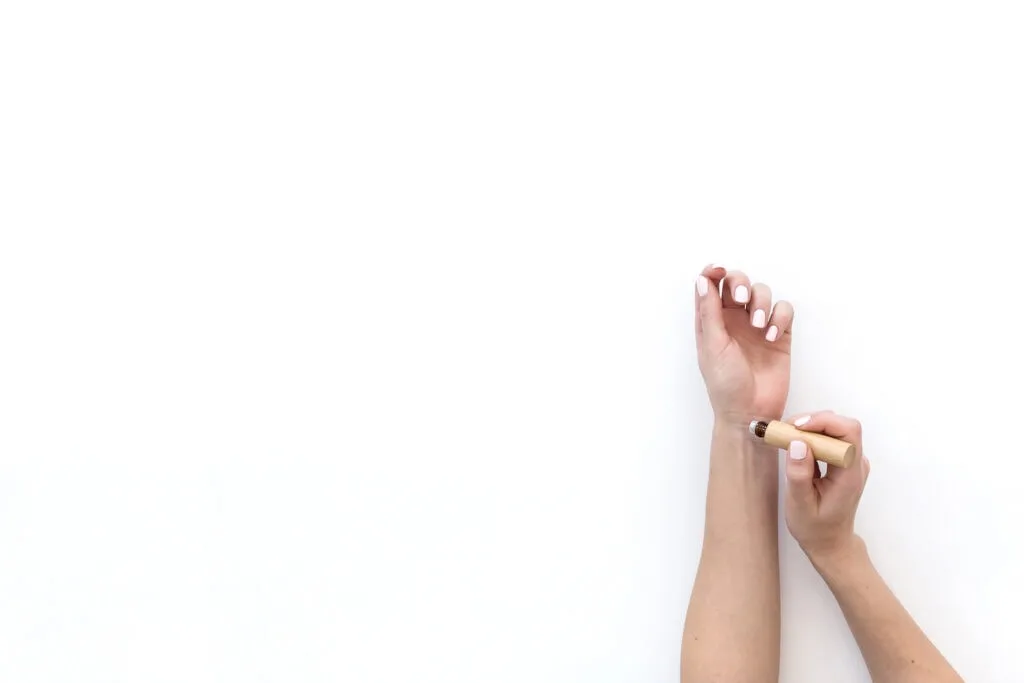 woman applying essential oil to wrist