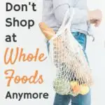 woman holding mesh grocery bag full of produce and bread