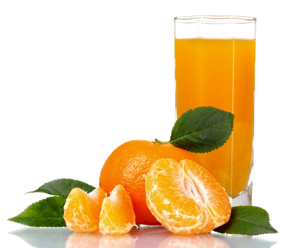 glass of tangerine juice against white background with fresh tangerines peeled