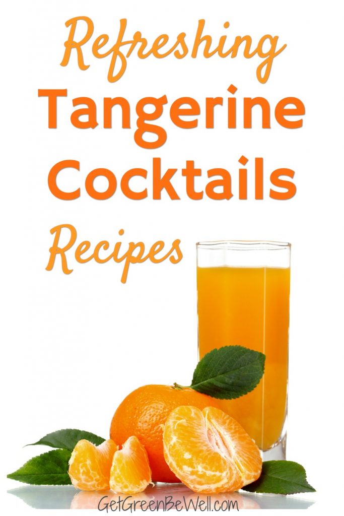 glass of tangerine juice with fresh fruit on table against white background