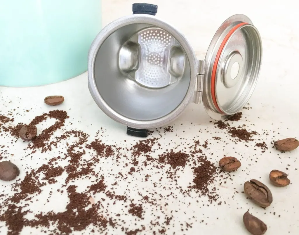 Reusable stainless steel K-cups coffee pods on white background with coffee beans 