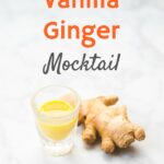 piece of ginger root next to small glass of orange liquid