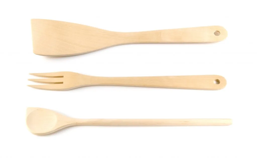 Wooden spoon, spatula, fork on a white background.