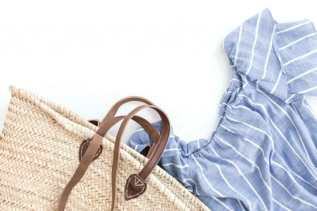 straw bag and denim shirt on white background