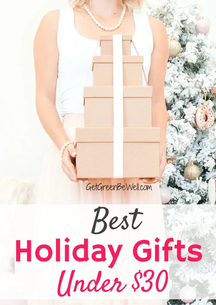 Woman holding stack of presents wrapped in brown paper and white bow holiday gift guide