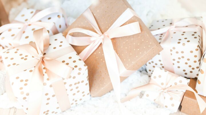 holiday gifts wrapped in brown and white paper with gold polka dots and pink bows holiday gift guide