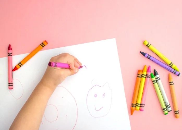 Kids hand coloring with crayons