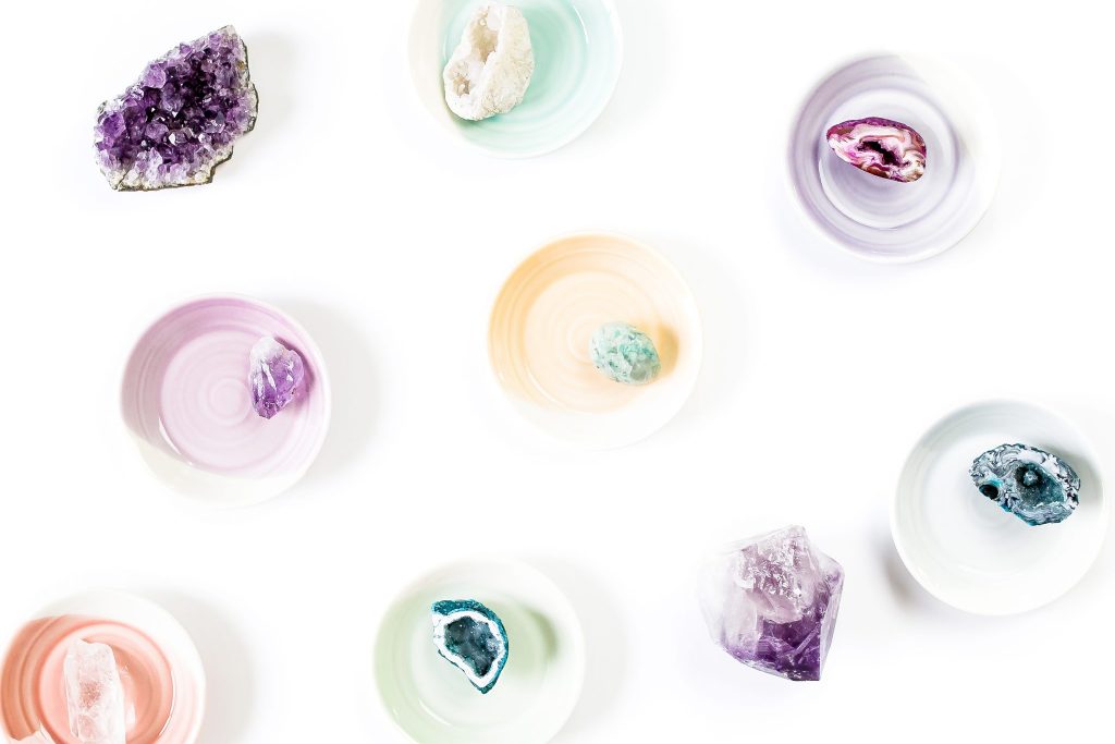 white background with pastel bowls filled with crystals