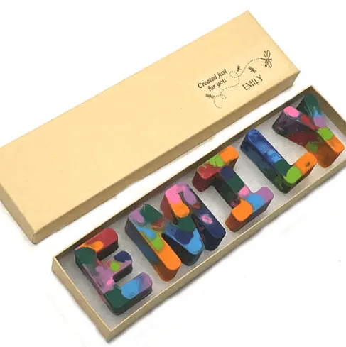 multicolored crayons in letters spelling out a name