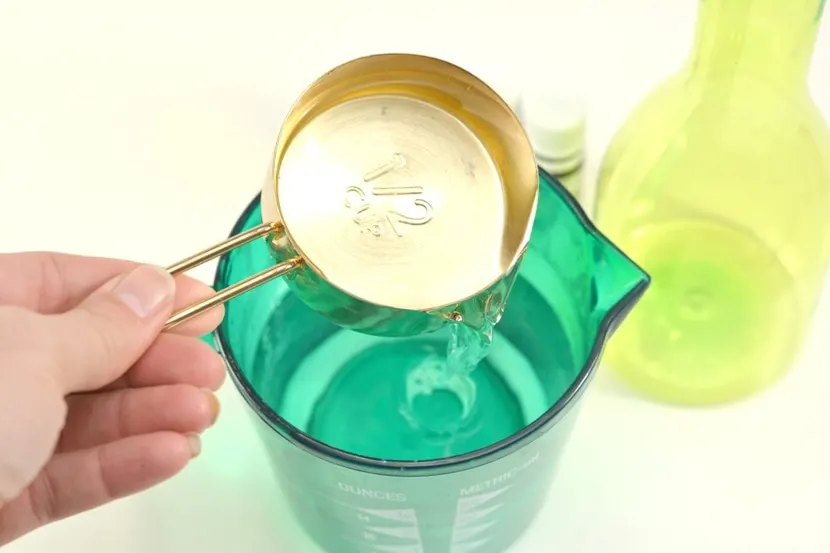 measuring cup of vinegar poured into water
