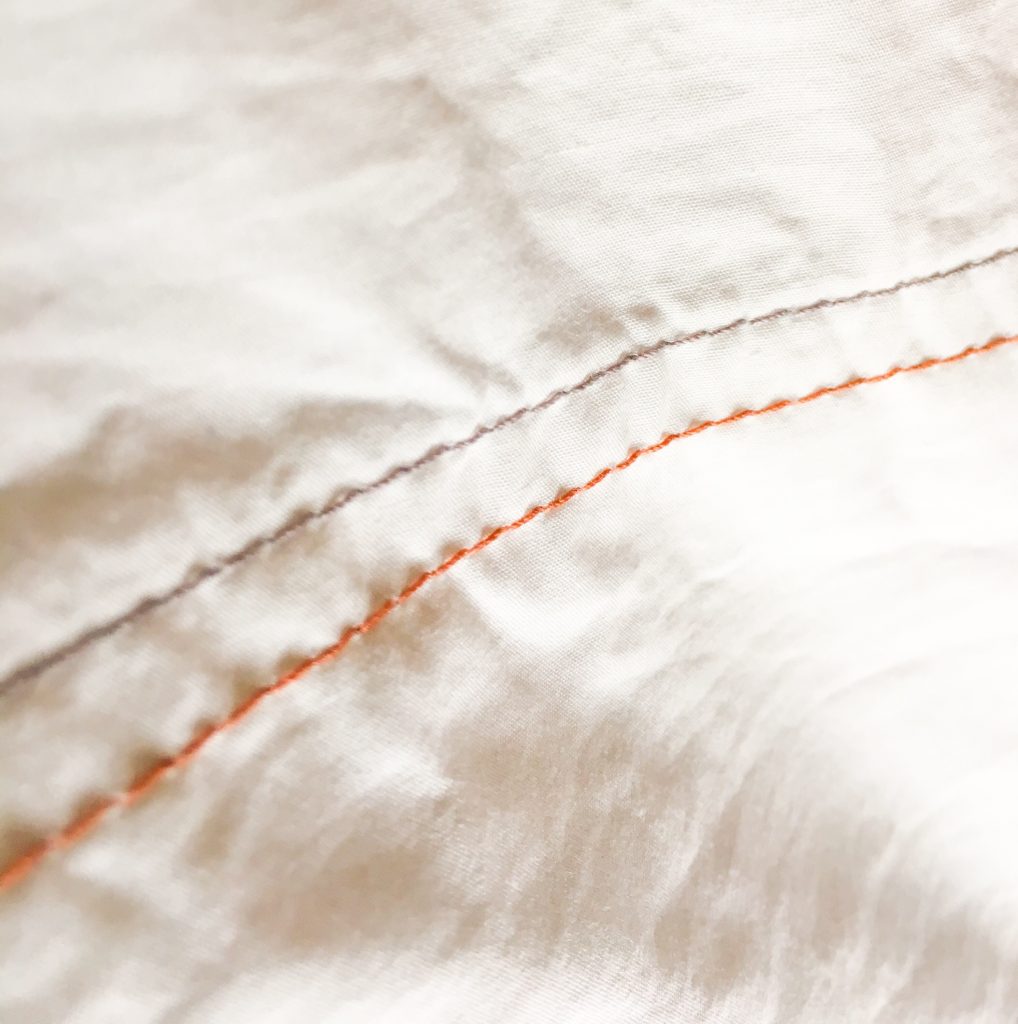 off white organic cotton sheets with grey and brown stitching