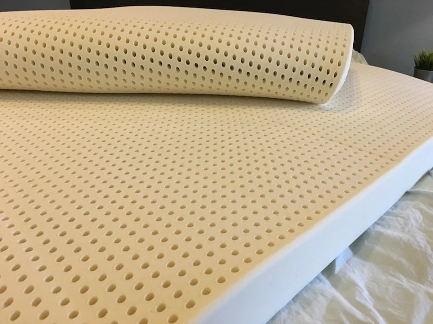 Latex for Less Mattress Topper unrolled on a bed