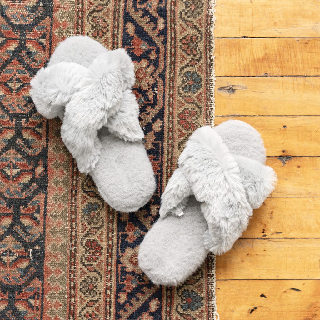 throw rug on wooden floor with grey fuzzy slippers