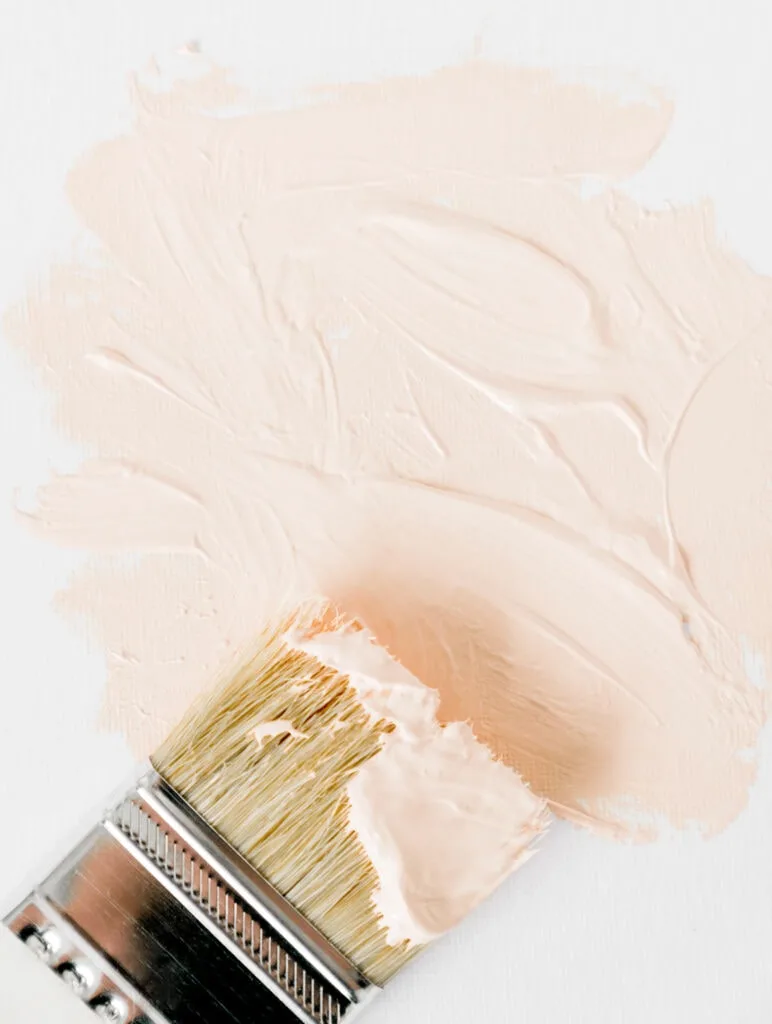 paint brush and pink paint on white wall