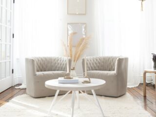 brown chairs on white rug with white end table in sunny room