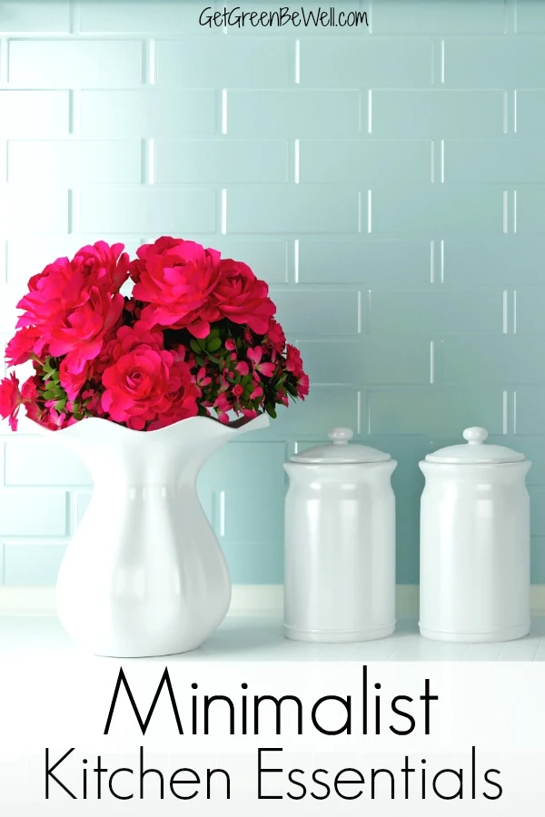 minimalist kitchen essentials on white countertop with vase of pink flowers