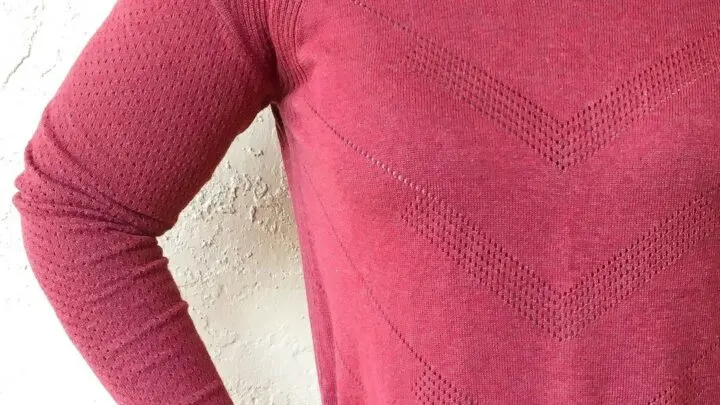 wine colored sweater against cream colored wall