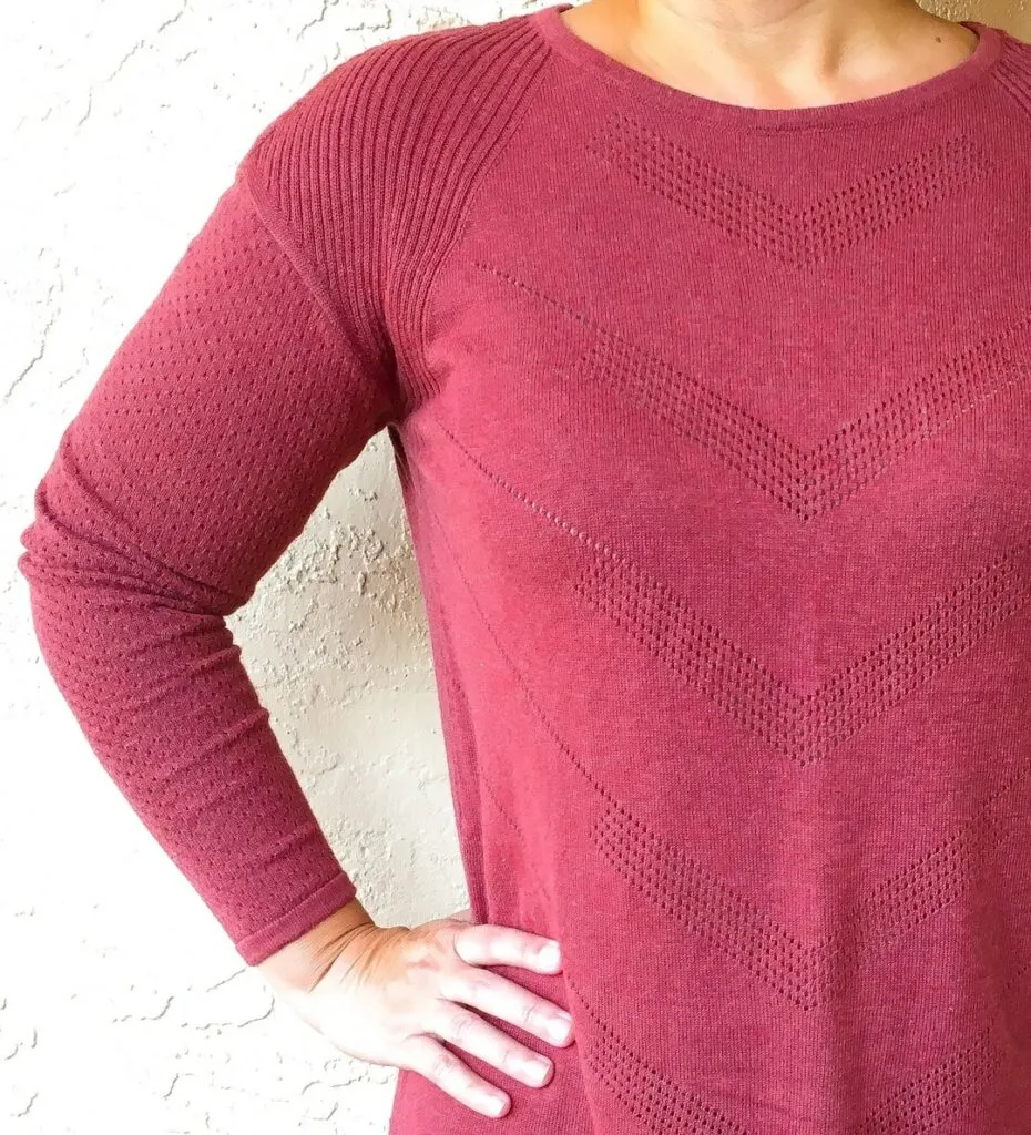 wine colored sweater against cream colored wall
