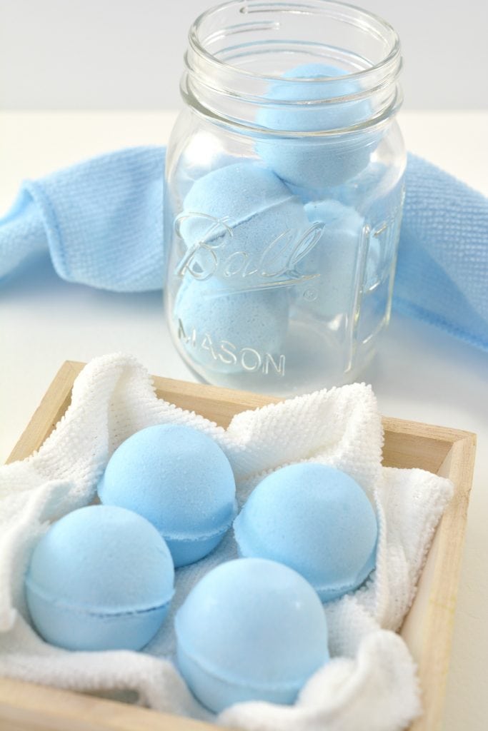 blue homemade toilet bowl cleaner tablets in wooden box and glass mason jar