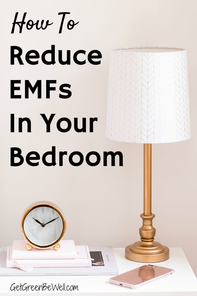 nightstand with gold lamp and battery operated clock on books against pink wall