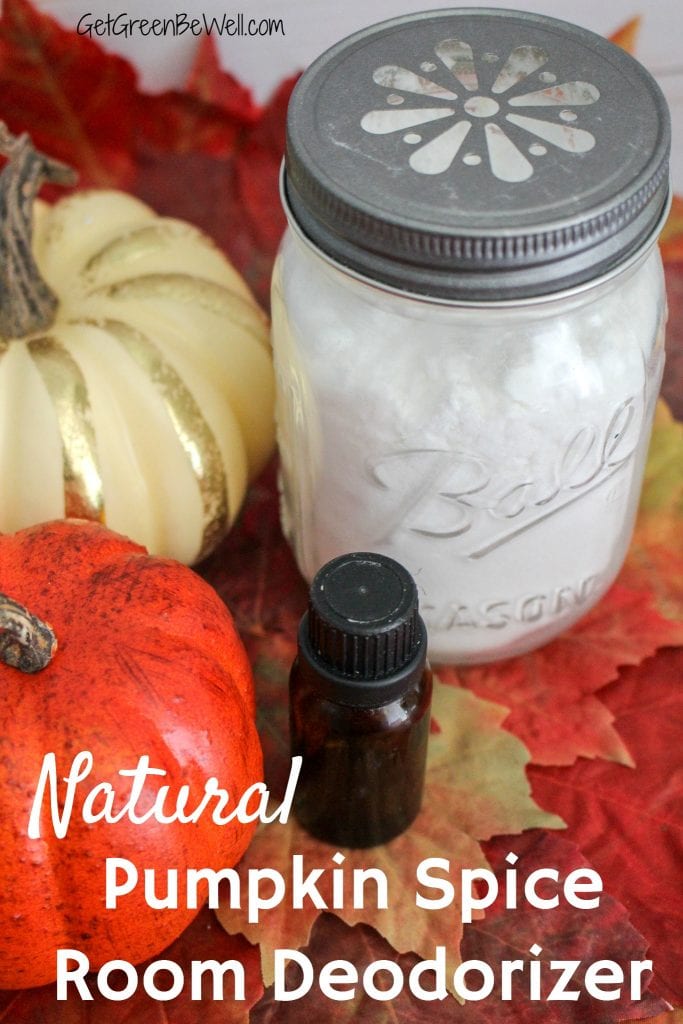 Glass jar with white baking soda against pumpkins, white wood background, fall leaves and essential oil bottle