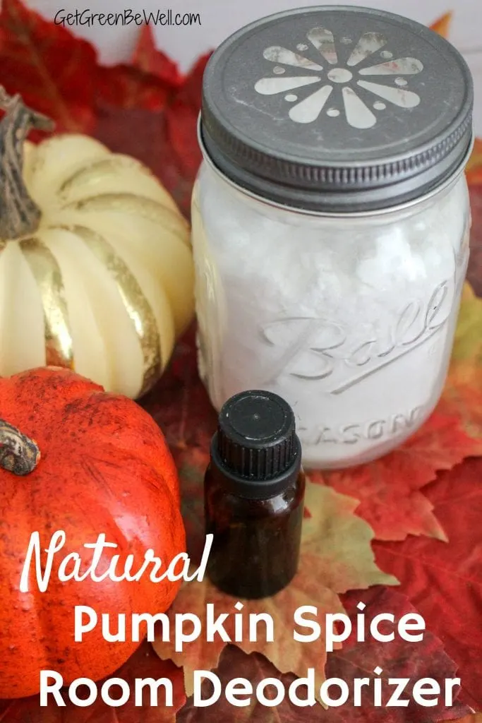 Glass jar with white baking soda against pumpkins, white wood background, fall leaves and essential oil bottle