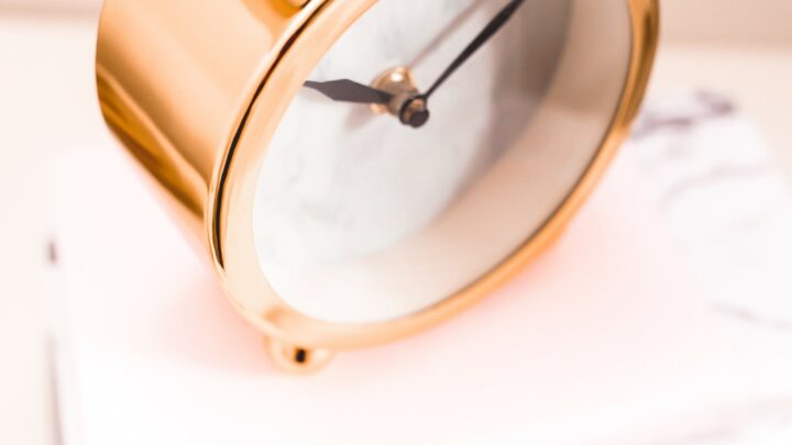 gold round battery powered alarm clock on marble table