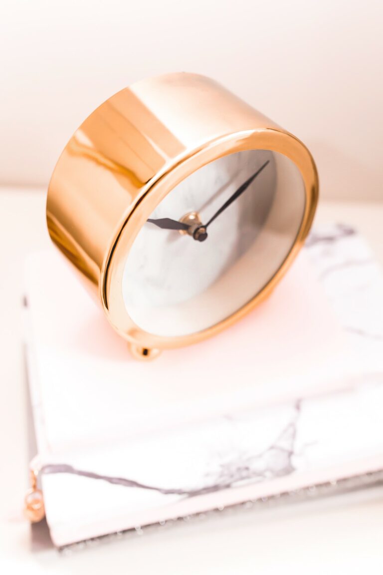 gold round battery powered alarm clock on marble table