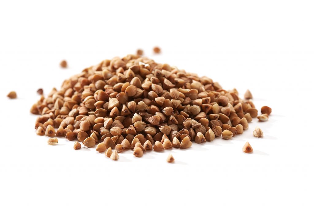 pile of buckwheat seeds on white background