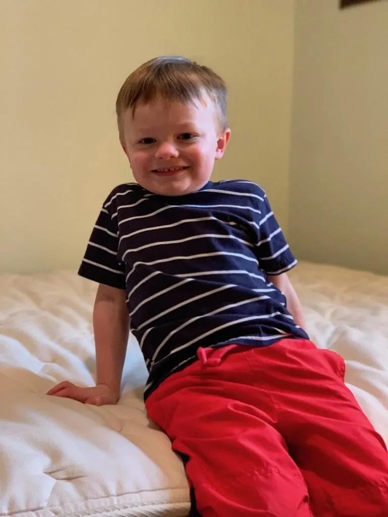 kid sitting on all natural material mattress