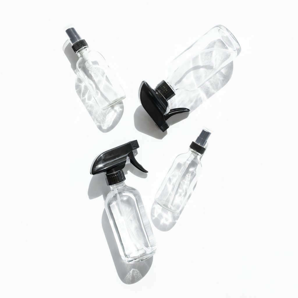clear spray bottles with black caps against white background