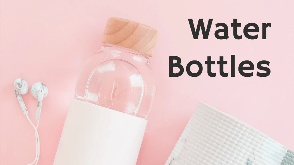 glass water bottle with cork lid and headphones against pink background