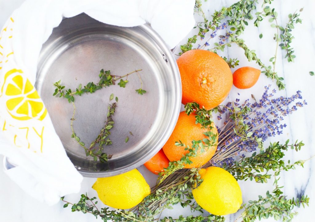 orange lemon lavender thyme herb on marble slab with stainless steel simmer pot and white towel for stove top potpourri