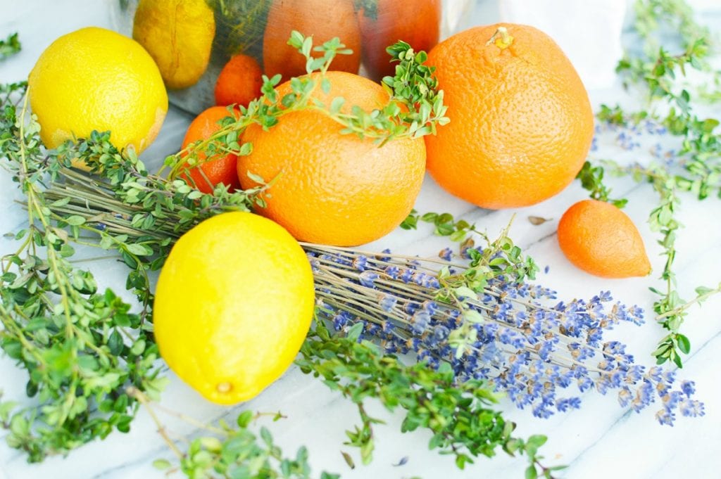 lemons oranges thyme herbs lavender flowers on white marble slab simmering stovetop popurri