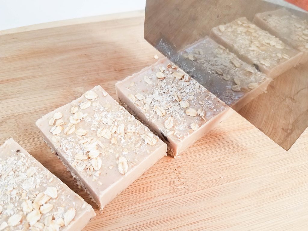 exfoliating Cinnamon Oatmeal Soap Bars being cut on wood surface