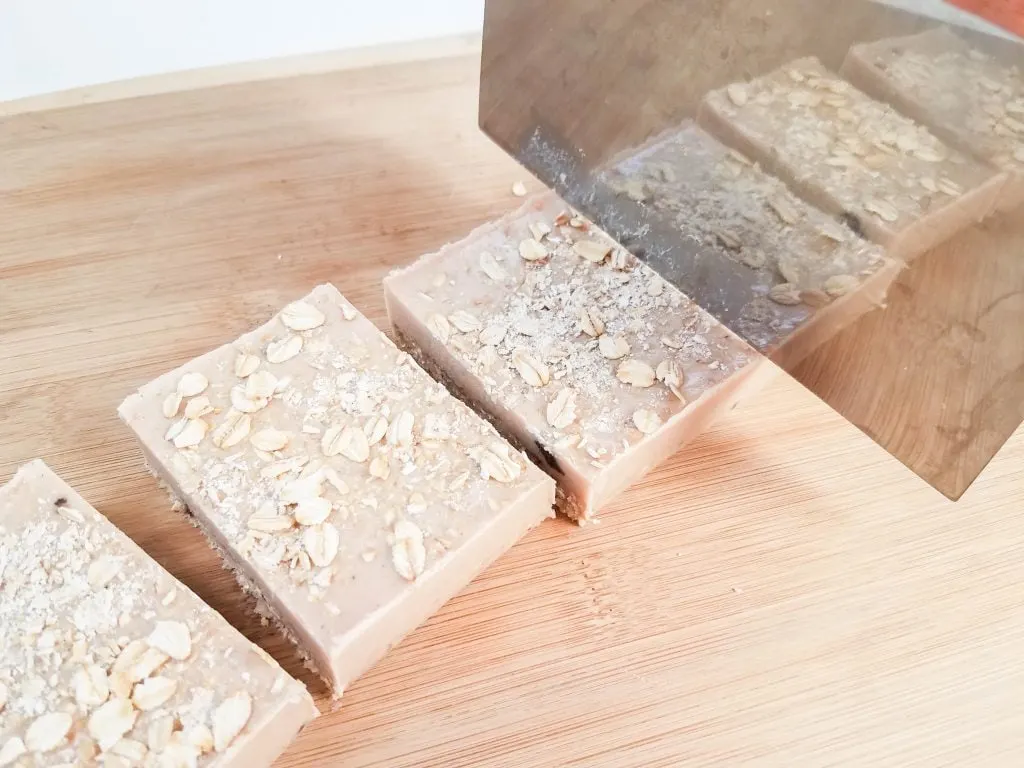 exfoliating Cinnamon Oatmeal Soap Bars being cut on wood surface