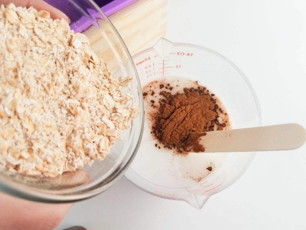 glass bowl of rolled oats poured into soap bar