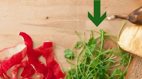 herb stems food waste on wooden board