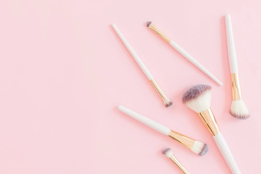 makeup brushes on pink background