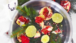Christmas stovetop potpourri in stainless steel pot against pine needles and white background