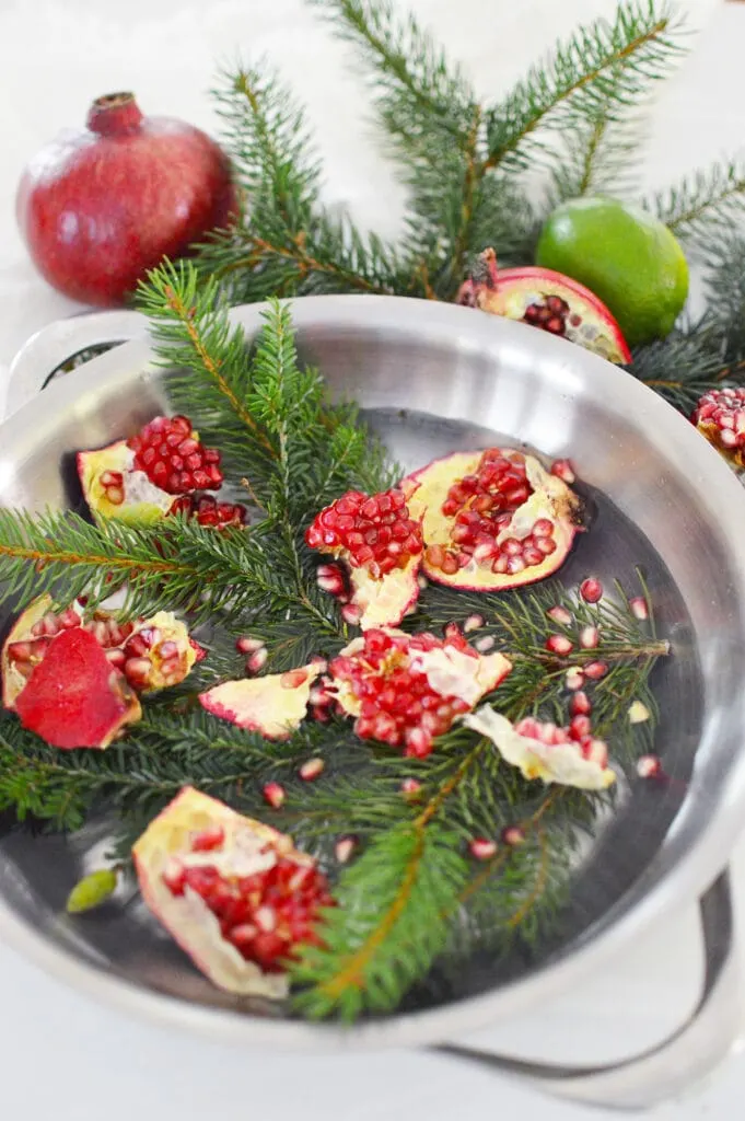 Christmas stovetop potpourri with pine needles pomegranate lime in steel pot